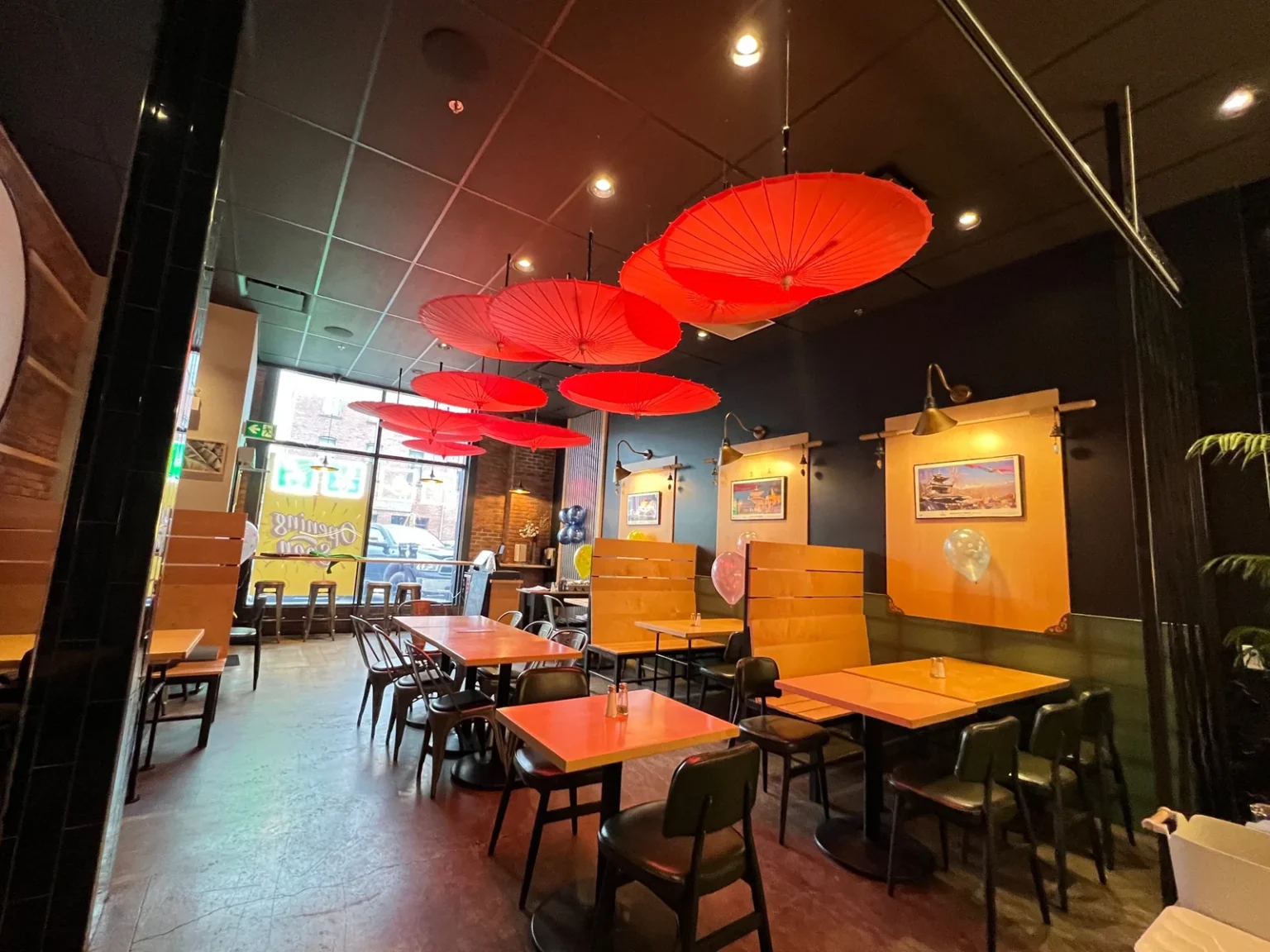 The dining room at The Island Restro & Bar, with red paper parasols hung from the ceiling